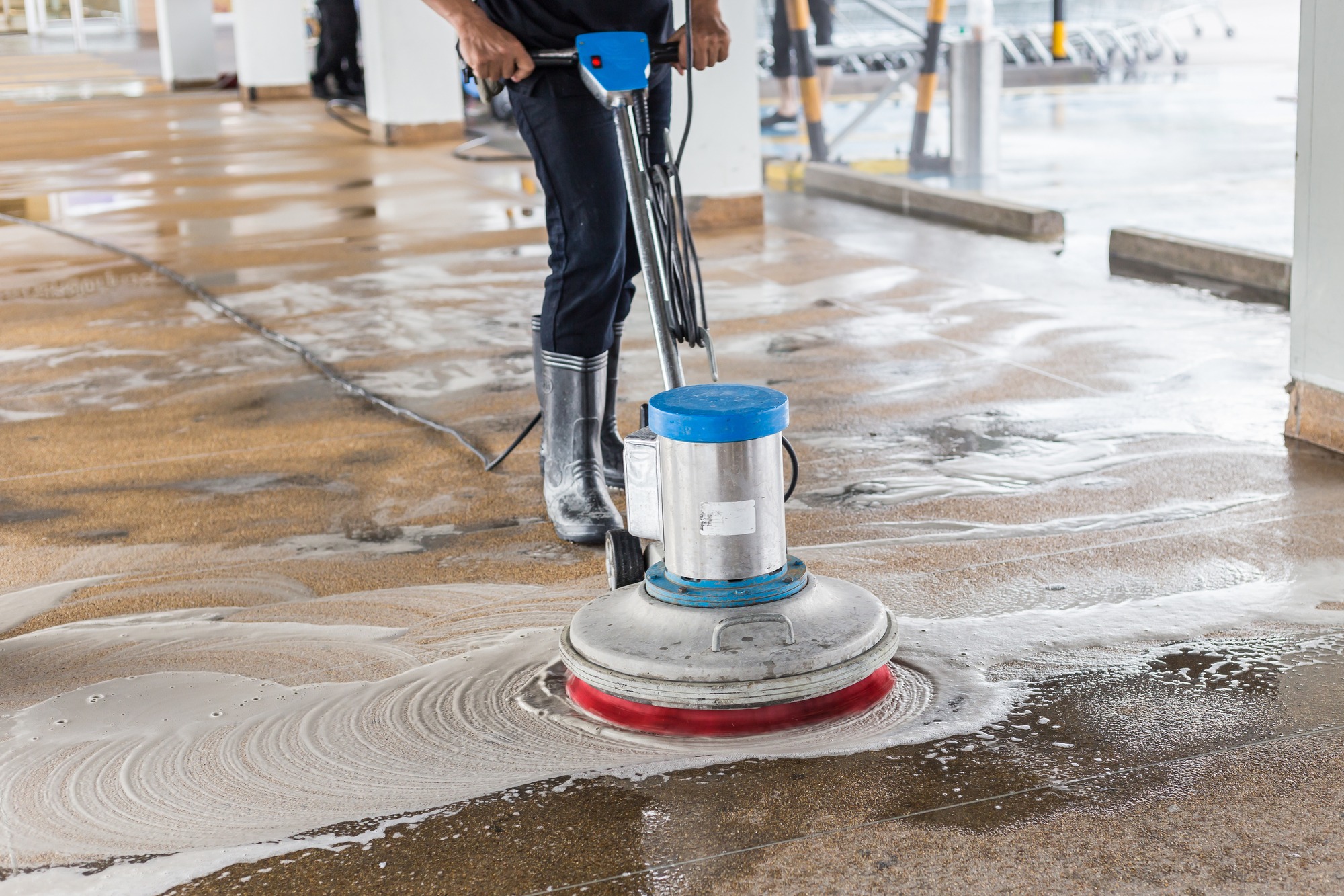 Asian worker cleaning sand wash exterior walkway using polishing machine and chemical or acid
