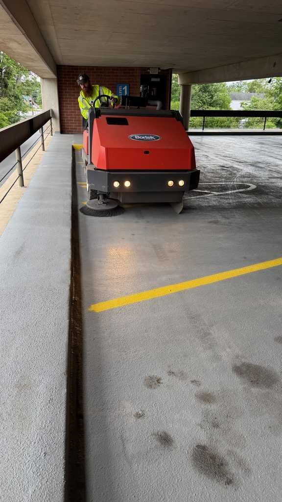 ASM Environmental commercial ride-on sweeper cleaning a parking garage in Wilkes-Barre, Pennsylvania.